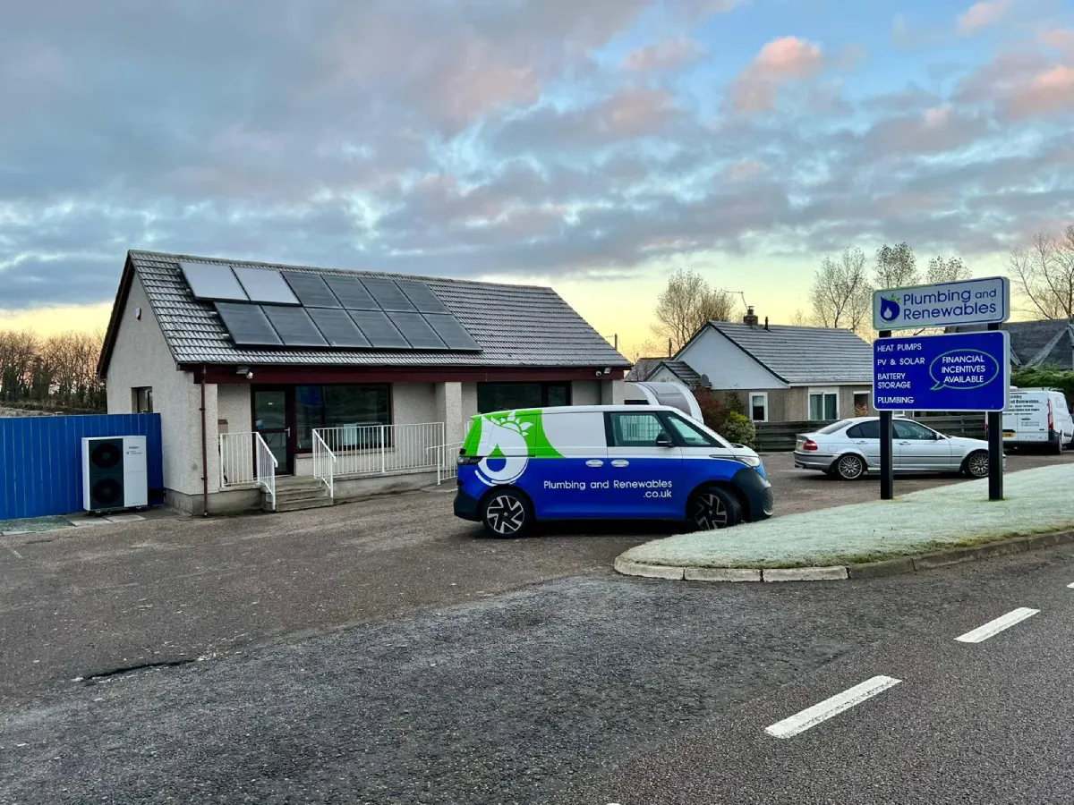 Building with solar panels and company van.